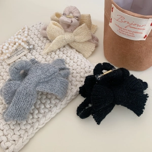 Pinces à cheveux nœud en tricot en quatre couleurs sur fond blanc avec perles douces