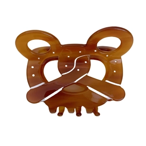 Retro amber pretzel-shaped acetate hair claw clip with realistic white salt-like details