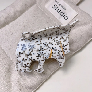Detail view of acetate leopard head hair claw with polished brown patterns and gold lines
