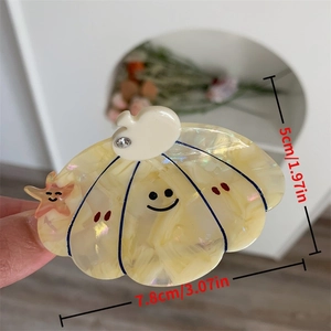 Medium acetate hair claw clip with smiling seashell design and small starfish detail