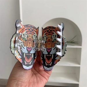 Gros plan sur une grande pince à cheveux tête de tigre avec motif orange et noir détaillé