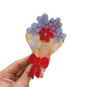 Pince à cheveux fleurie en acétate avec pétales bleus, nœud rouge et cristaux