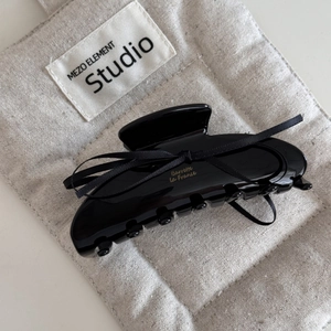 Détail de la pince à cheveux noire avec nœud en soie et lettrage doré de style français