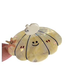 Shell-shaped acetate hair claw clip with pearl marble texture and smiling face design