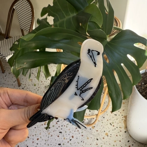 Détail d'une pince à cheveux en acétate en forme de fou de Bassan avec accents bleus