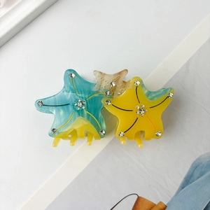 Close-up of starfish hair claws with colorful acetate texture and sparkling rhinestones