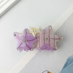 Close-up of starfish acetate hair claw with purple marbling and rhinestone accents