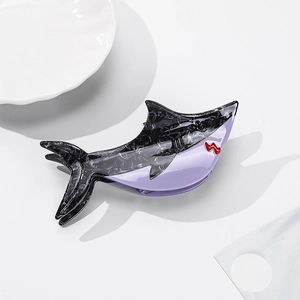 Detailed view of shark-shaped hair claw clip with marble texture and purple finish