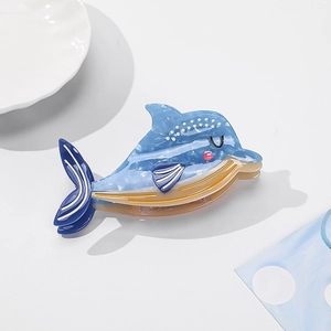 Detail of blue marble texture dolphin hair claw clip with shell and artistic props