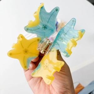 Starfish shaped acetate hair claw clip with yellow and blue marble pattern for women