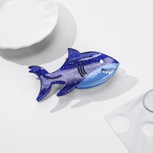 Detail of shark-shaped hair claw with dark blue glitter finish and fine craftsmanship
