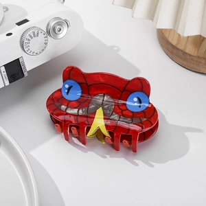 Close-up detail of a red snake-shaped hair claw clip with blue eyes and yellow forked tongue