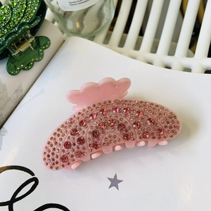 Détail de la pince à cheveux rose avec strass brillants et finition en acétate