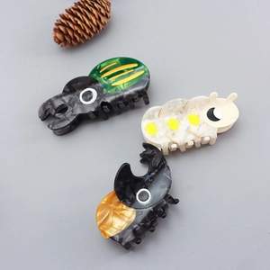 Three-piece acetate hair claw set featuring colorful insect designs of beetles and caterpillars