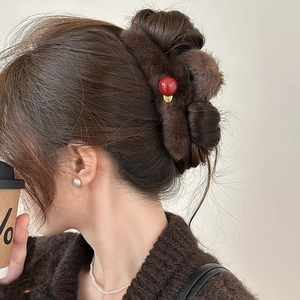 Plush faux fur shark hair claw clip in deep brown with red bead detail on model