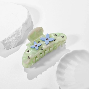Elegante pinza per capelli in acetato verde marmorizzato con fiori blu e accenti di strass