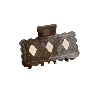 Pince à cheveux carrée marron foncé style biscuit avec motifs losanges sur fond blanc