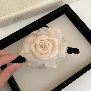 Gros plan d'une pince à cheveux rose en tissu champagne sur un plateau cadre vintage