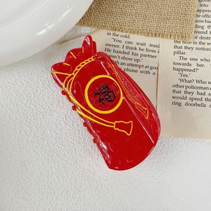 Detail of red acetate hair claw clip shaped like a lucky pouch with Fu character