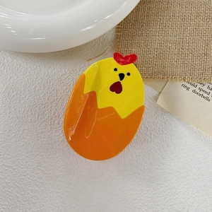 Détail de la pince à cheveux mignonne en forme de poussin jaune et orange en acétate