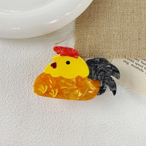 Vue détaillée de la pince à cheveux coq en acétate montrant la texture polie et les couleurs