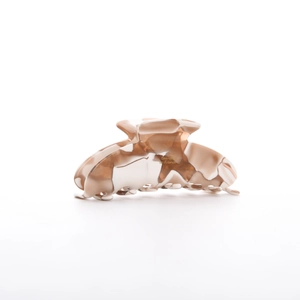 Close-up of marbled brown and white acetate shark clip with golden Barrette France text