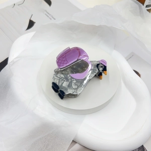 Detail of penguin shaped acetate hair claw clip with grey marble pattern and purple accents