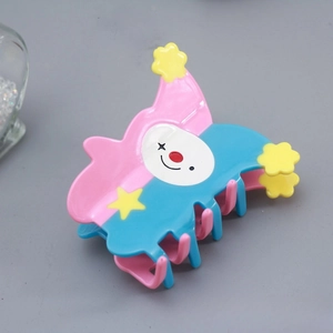 Detail view of clown hair claw clip with pink blue patchwork and yellow star decor