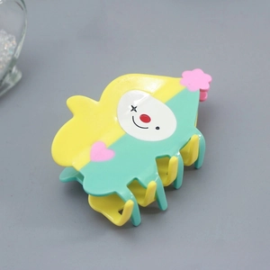 Detail of colorful clown hair claw clip in yellow and mint green acetate material