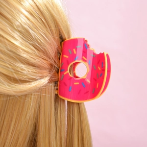 Pince à cheveux rose en forme de donut avec pépites colorées sur cheveux blonds