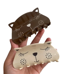 Cute squinting cat acetate hair claws in dark brown and beige colors with a glossy finish