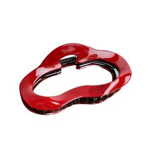 Glossy red wavy hair claw clip with black interior and metal spring on white background