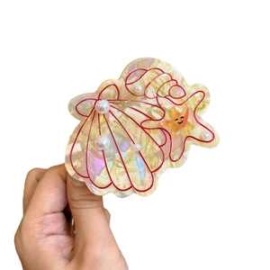 Pearlescent ocean theme hair claw clip with starfish shell designs and pearl accents
