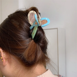 Detail of blue and beige marbled butterfly hair claw clip with golden star patterns