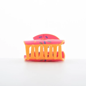 Détail d'une pince à cheveux donut mignonne avec vermicelles colorés rose et jaune