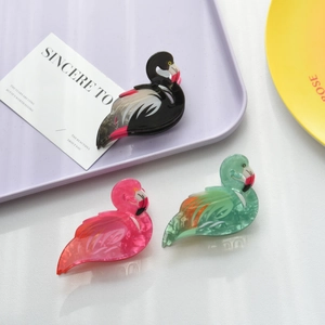 Detailed shot of flamingo hair claws in black, peach pink, and mint green marble acetate