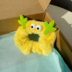 Chouchou monstre en peluche jaune mignon avec yeux amusants dans une boîte