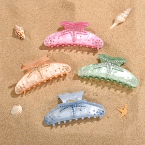 Detail of colorful acrylic starfish hair claws with sparkling rhinestones in four summer colors