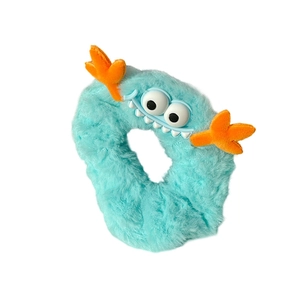 Chouchou monstre en peluche bleu clair avec des yeux de dessin animé et antennes