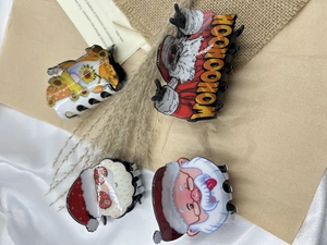 Set di quattro pinze per capelli natalizie con motivi di Babbo Natale e gnomi