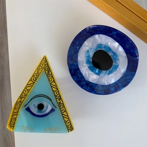 Acetate geometric hair claws featuring evil eye and triangle all-seeing eye designs