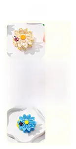 Detail of floral hair claws in yellow, pink and blue with small ladybug accents