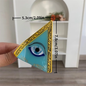 Detail view of triangular evil eye hair claw clip in sky blue with gold embossed edges