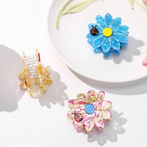 Floral acetate hair claw clips in blue, amber, and pink patterns with metal springs