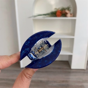 Detail showing marble texture blue acetate hair claw with transparent spring cover