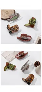 Detail view of acetate hair clips in cowboy hat and boot shapes with vintage star patterns