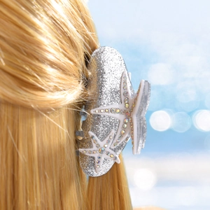 Détail de la pince à cheveux étoile de mer avec strass colorés sur cheveux blonds