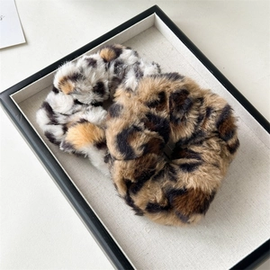 Detailed texture of leopard print plush scrunchies in white and dark coffee brown