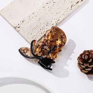 Detail view of retro cowboy boot shaped hair claw clip made of brown acetate