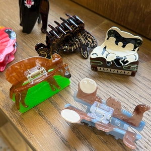 Flat lay detail of acetate animal hair claws featuring panda, dog, and insect designs